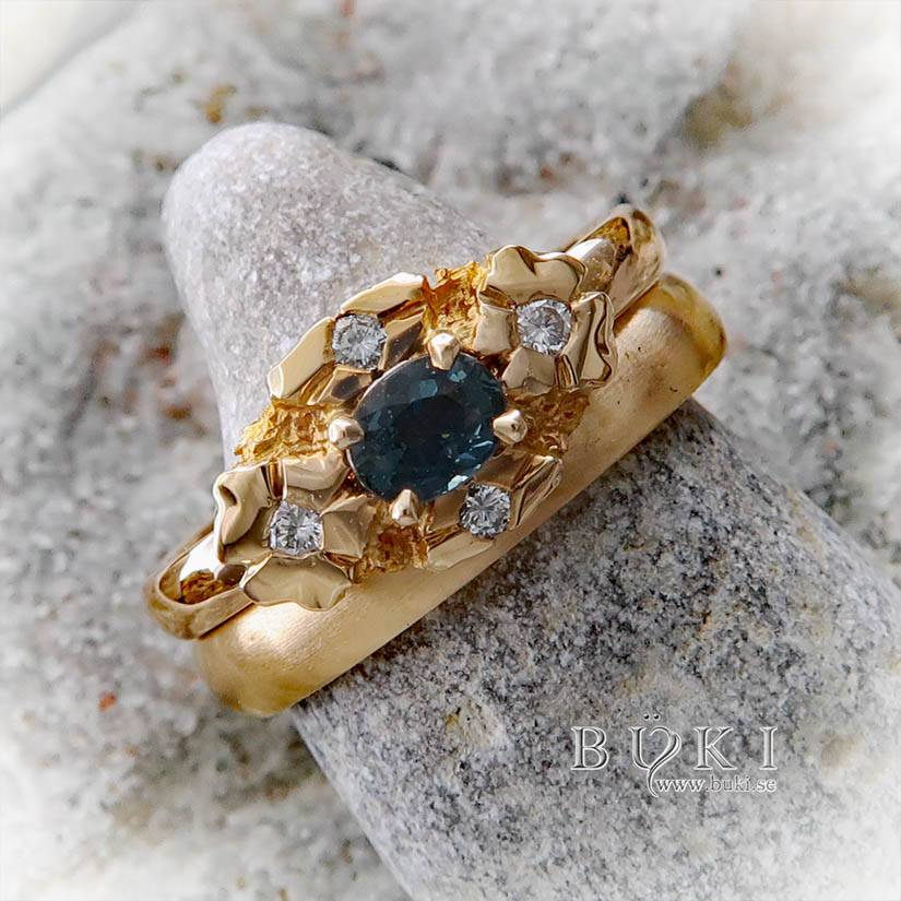 blom-ring halo-ring i 18k guld med petrol safir och diamanter bredvid slät guldring