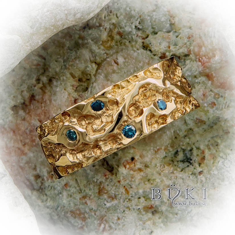 Ravinsjöar-bred guldring i 18k med blå diamanter
